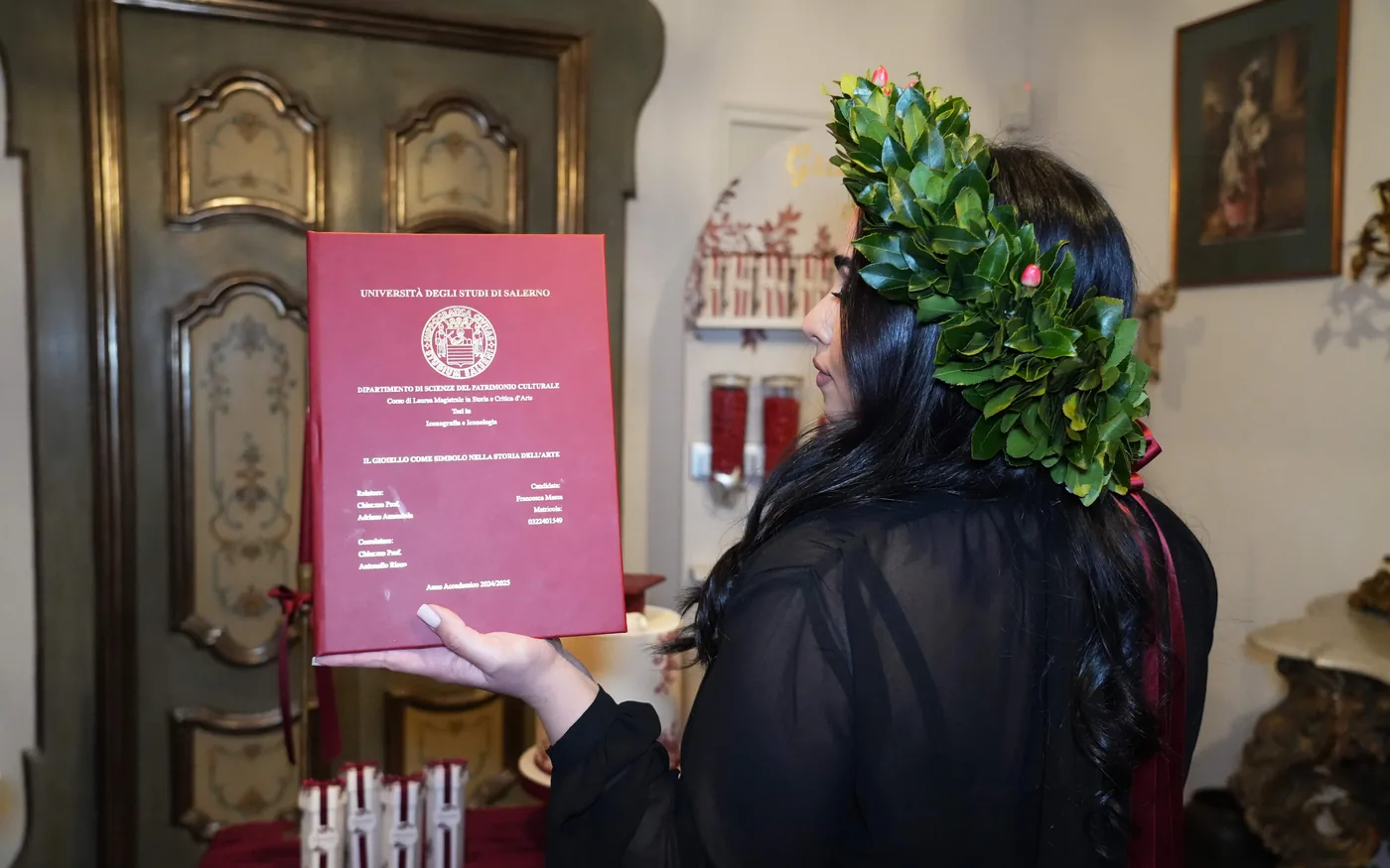Neolaureata con la corona d'alloro mostra la tesi nelle sale della Tenuta Don Gaetano