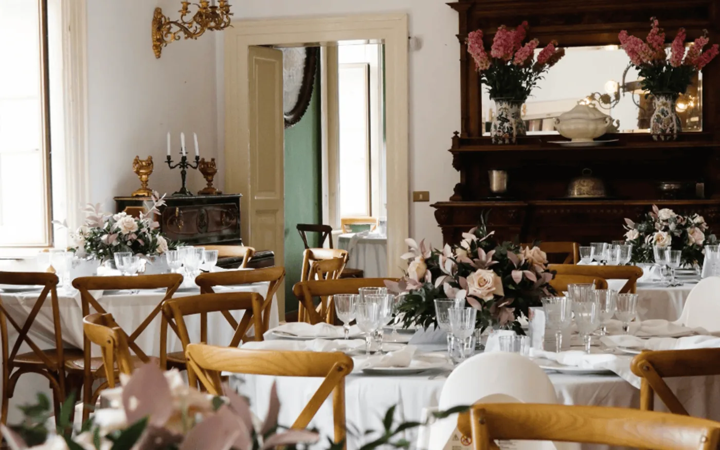 Tavoli apparecchiati con composizioni di rose per una promessa di matrimonio alla Tenuta Don Gaetano