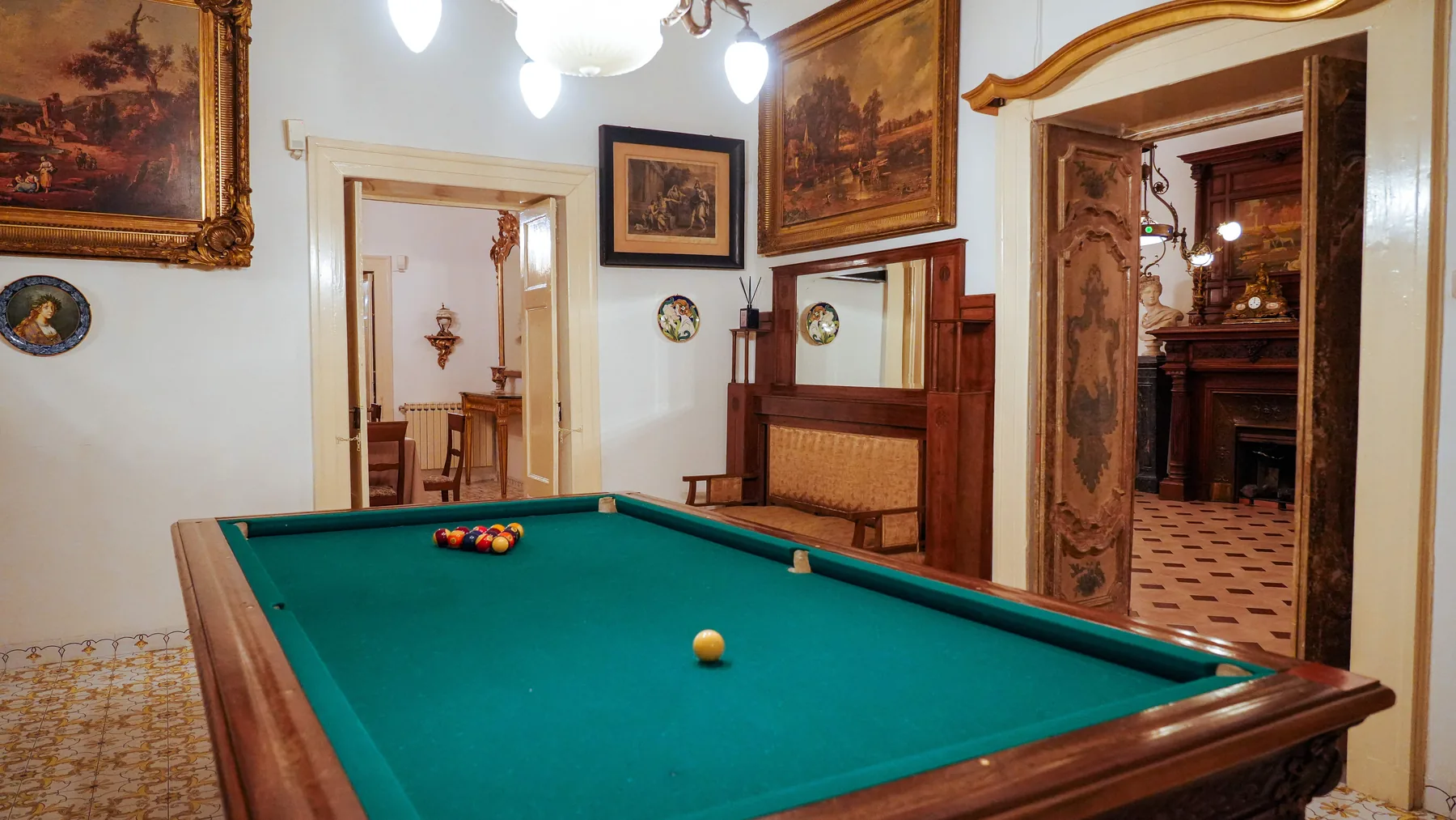 La sala del biliardo con le porte dipinte e l'enfilade delle sale