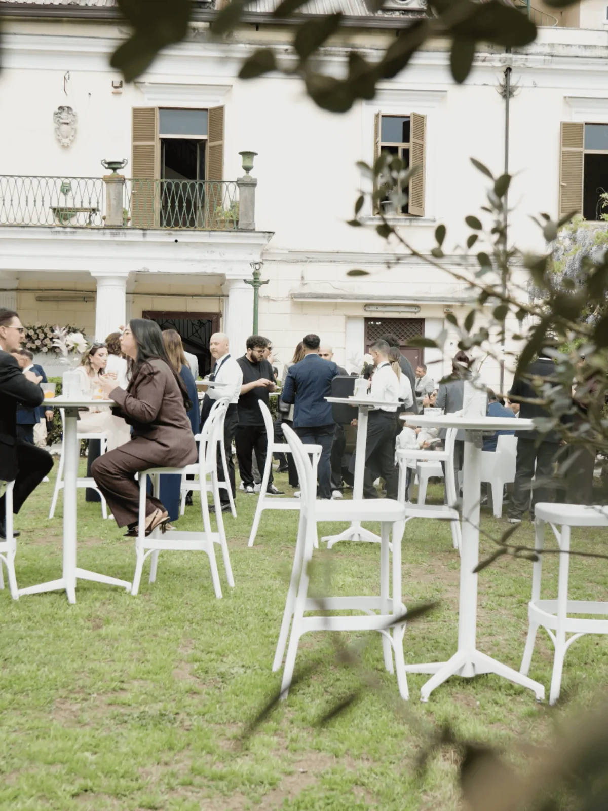 Ospiti al ricevimento in giardino davanti alla facciata della dimora