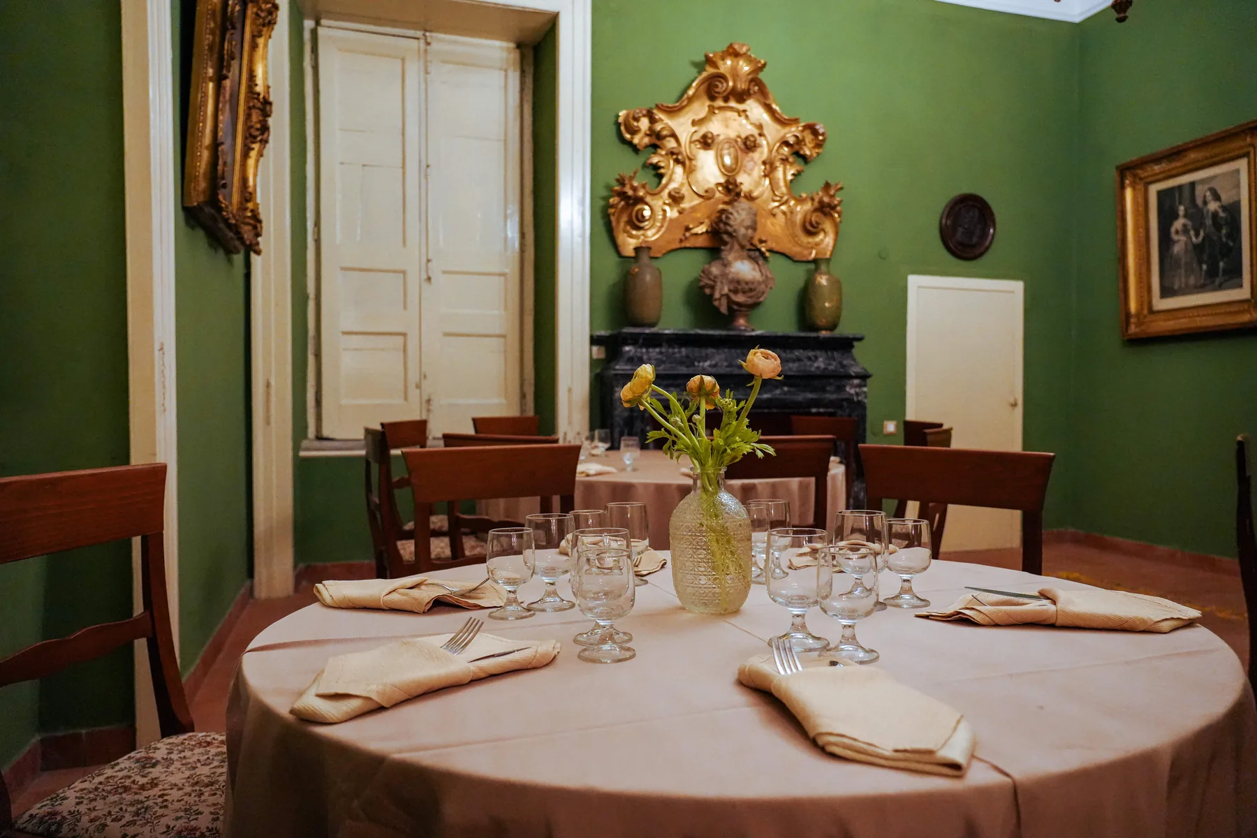 La sala verde della Tenuta Don Gaetano con la tavola apparecchiata e la specchiera dorata